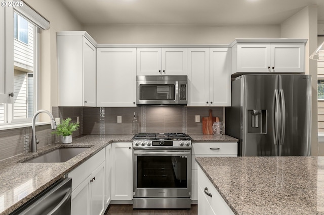 14152 SW Compass Dr, Beaverton, OR 97005 - kitchen featuring stainless steel appliances, decorative backsplash, white cabinetry, and light stone countertops