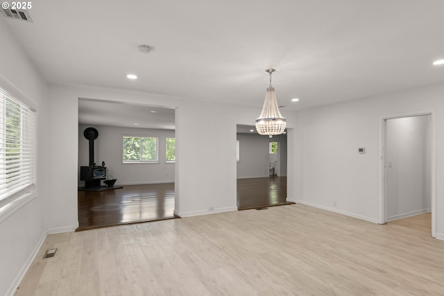 11744 SW 61st Ave, Portland, OR 97219 - spare room with light wood-type flooring, a wood stove, recessed lighting, a chandelier, and a smoke detector