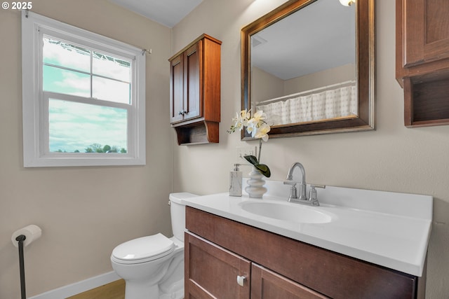 full bathroom with vanity, baseboards, and toilet