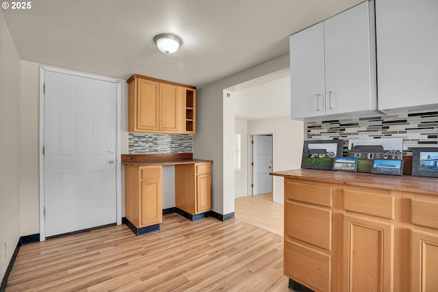 kitchen featuring decorative backsplash, open shelves, butcher block counters, baseboards, and light wood finished floors