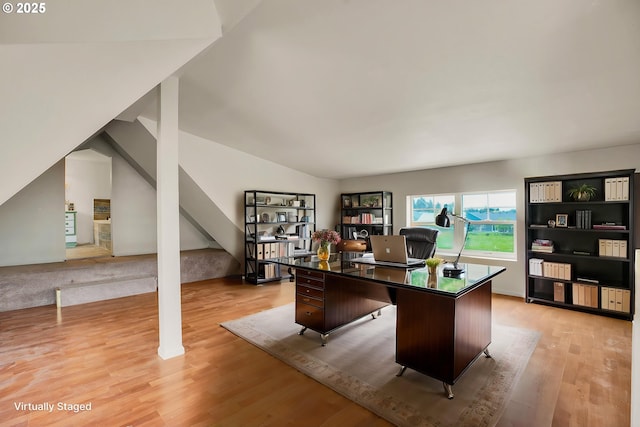 office space with light wood-style floors and lofted ceiling