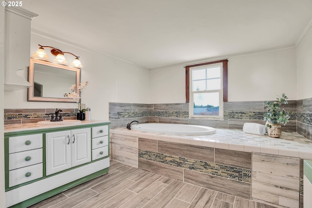 bathroom with crown molding, a garden tub, vanity, wood finished floors, and backsplash