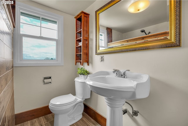 bathroom featuring toilet, baseboards, and wood finished floors
