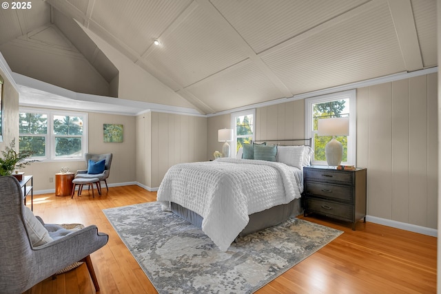 bedroom featuring baseboards, hardwood / wood-style floors, and lofted ceiling