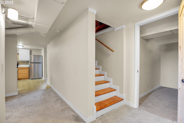stairway featuring carpet floors and baseboards