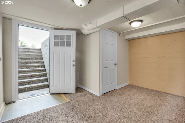 below grade area with carpet floors, baseboards, and stairs