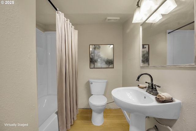 full bath featuring visible vents, wood finished floors, shower / bath combination with curtain, and toilet