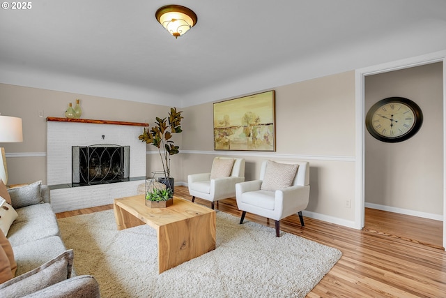 living room with baseboards, wood finished floors, and a fireplace