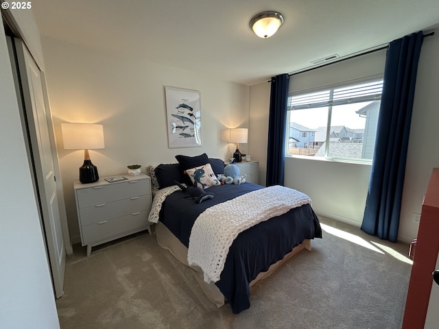 carpeted bedroom featuring visible vents and a closet
