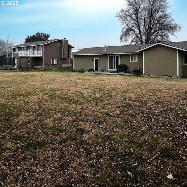 rear view of house with cooling unit and a lawn