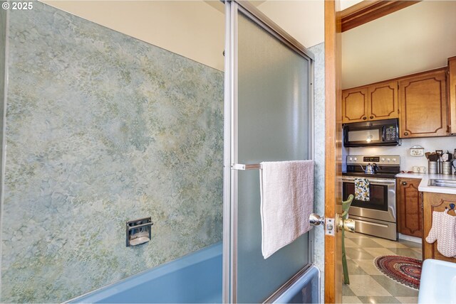 bathroom with tile patterned floors and bath / shower combo with glass door