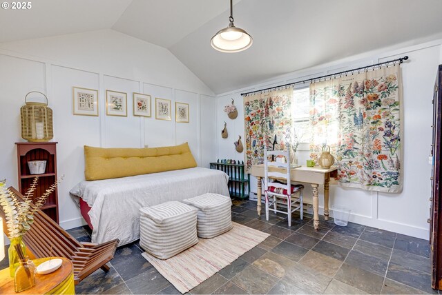 bedroom with vaulted ceiling and a decorative wall