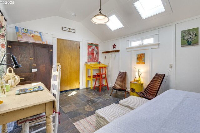 bedroom featuring stone tile floors and vaulted ceiling with skylight