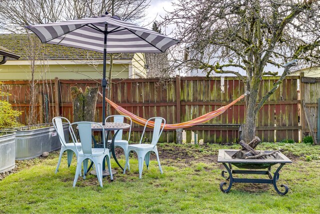 view of yard with fence and a fire pit