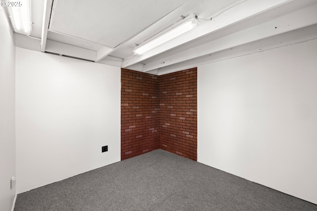 finished basement with carpet floors and brick wall