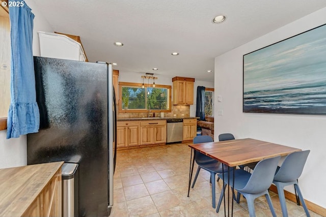 kitchen featuring sink, light tile patterned floors, appliances with stainless steel finishes, light stone counters, and decorative backsplash