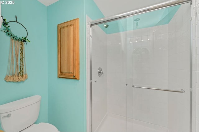 bathroom with a shower with door and toilet