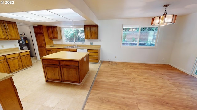 kitchen with sink, dishwasher, pendant lighting, and a center island