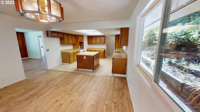 kitchen with a kitchen island, an inviting chandelier, a wealth of natural light, and pendant lighting