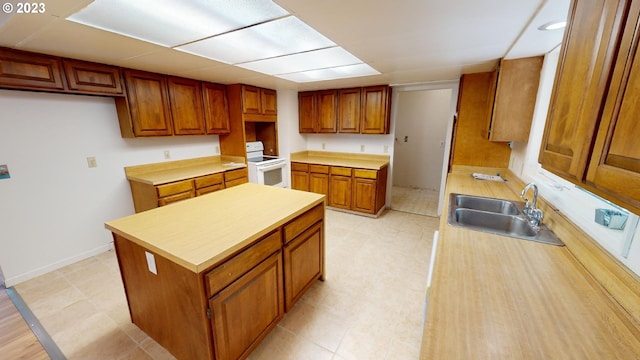 kitchen featuring electric range, a center island, and sink