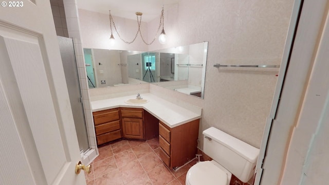 bathroom with toilet, an enclosed shower, an inviting chandelier, and vanity