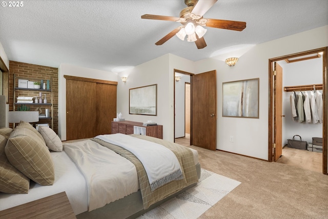 bedroom featuring light colored carpet, a textured ceiling, baseboards, a ceiling fan, and a closet