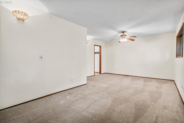 carpeted spare room with a ceiling fan, a textured ceiling, and baseboards
