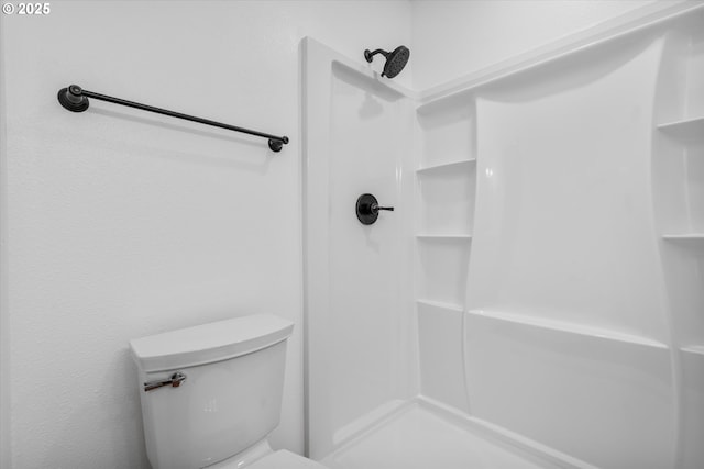 bathroom featuring a shower and toilet