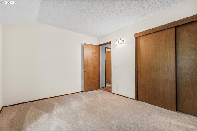 1200 NE Territorial Rd Unit 73, Canby, OR 97013 - unfurnished bedroom with carpet flooring, a closet, lofted ceiling, baseboards, and a textured ceiling