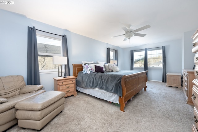 bedroom with light carpet, ceiling fan, and baseboards