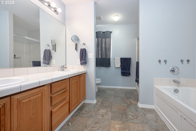 full bath with a sink, a shower stall, toilet, and double vanity