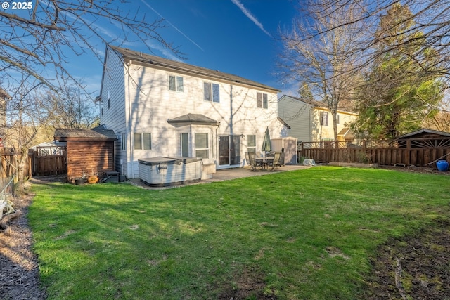 rear view of house featuring a patio, a yard, a fenced backyard, and a hot tub