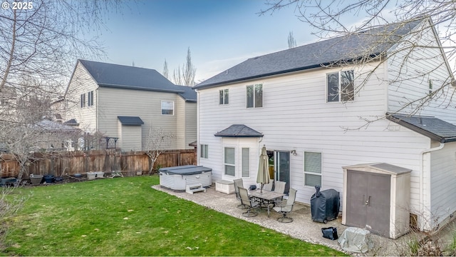 rear view of house featuring a yard, a patio area, fence, and a hot tub