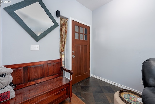 entryway featuring baseboards and stone finish floor