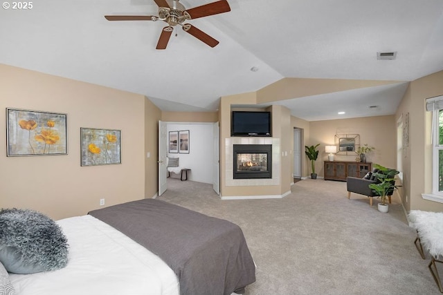 bedroom featuring visible vents, a ceiling fan, a tile fireplace, lofted ceiling, and light colored carpet