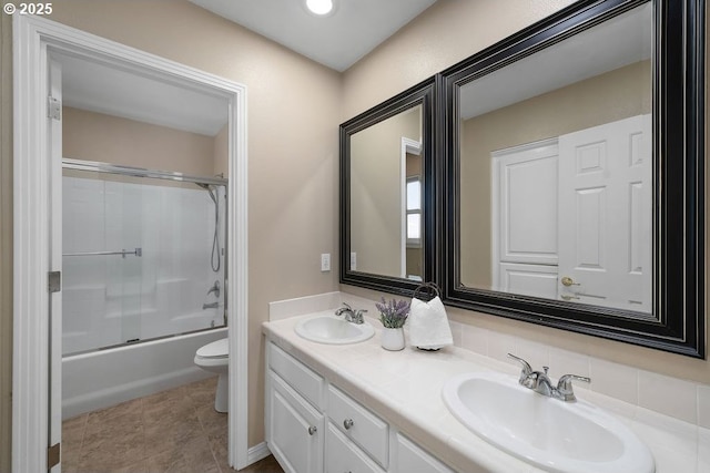 full bath with enclosed tub / shower combo, double vanity, a sink, and toilet