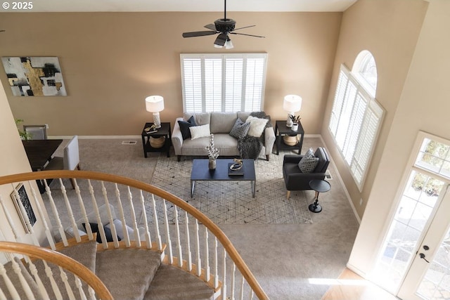 interior space with stairs, a ceiling fan, and baseboards