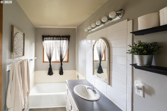 bathroom featuring vanity and a washtub