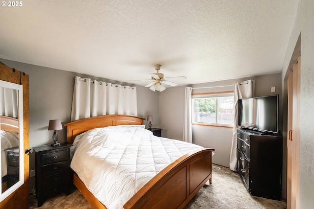 carpeted bedroom with ceiling fan and a textured ceiling