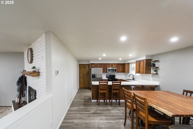 dining space featuring wood-type flooring, a fireplace, and sink