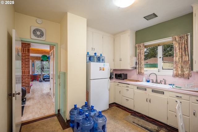 1034 Lawrence St, Eugene, OR 97401 - kitchen featuring freestanding refrigerator, light countertops, and white cabinets