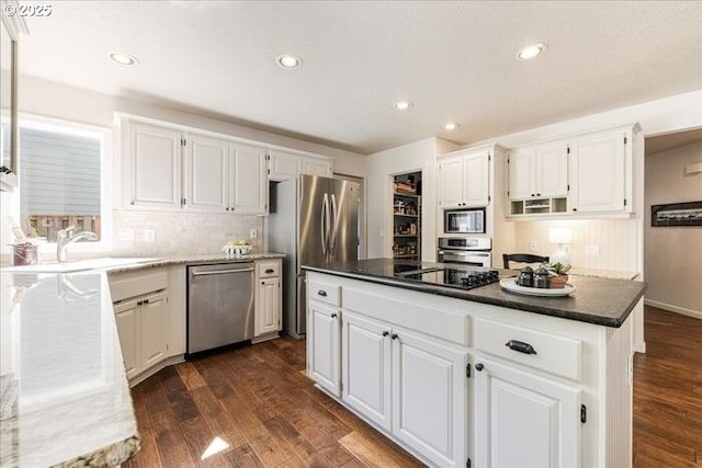 14940 SW Michael Ct, Sherwood, OR 97140 - kitchen with appliances with stainless steel finishes, dark wood-style floors, white cabinets, a kitchen island, and recessed lighting