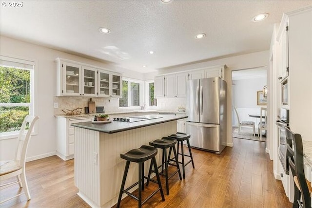 14940 SW Michael Ct, Sherwood, OR 97140 - kitchen featuring appliances with stainless steel finishes, decorative backsplash, a kitchen breakfast bar, a center island, and recessed lighting