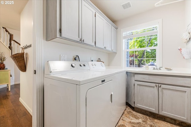14940 SW Michael Ct, Sherwood, OR 97140 - washroom with washing machine and dryer, cabinet space, wood finished floors, and baseboards