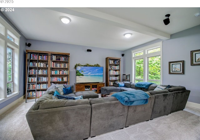 living room with beamed ceiling, plenty of natural light, and light colored carpet