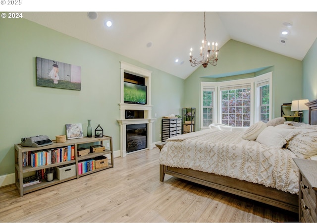 bedroom with lofted ceiling, wood finished floors, baseboards, a glass covered fireplace, and an inviting chandelier