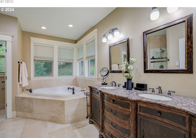 bathroom with double vanity, tiled shower, a sink, and a bath