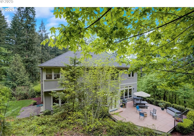 rear view of property featuring a shingled roof