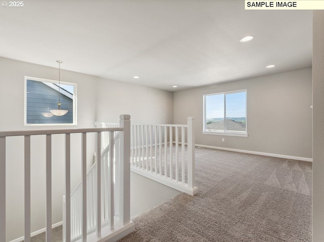 hallway with an upstairs landing, recessed lighting, baseboards, and carpet