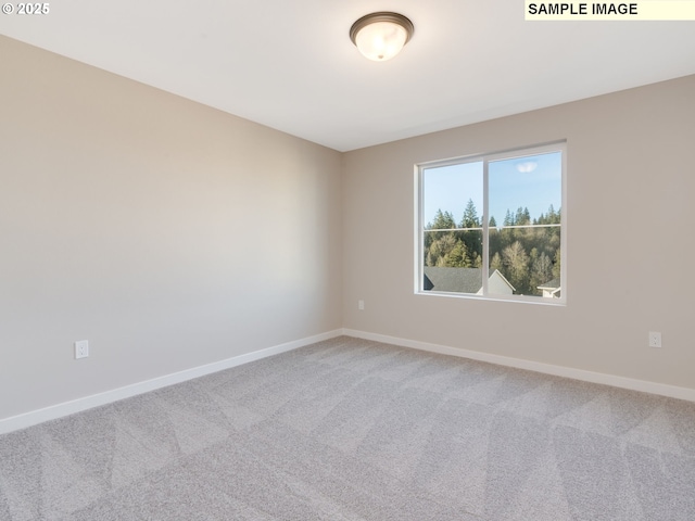 unfurnished room with light carpet and baseboards